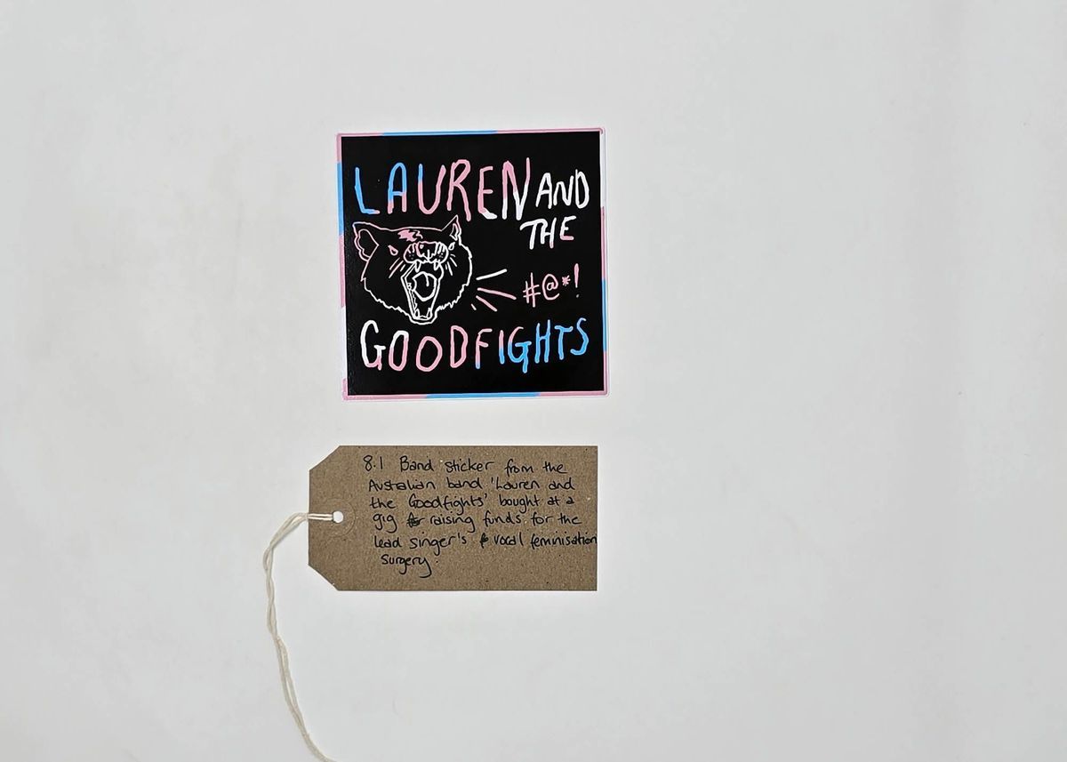The image shows a band sticker alongside a handwritten tag describing its significance and origin.