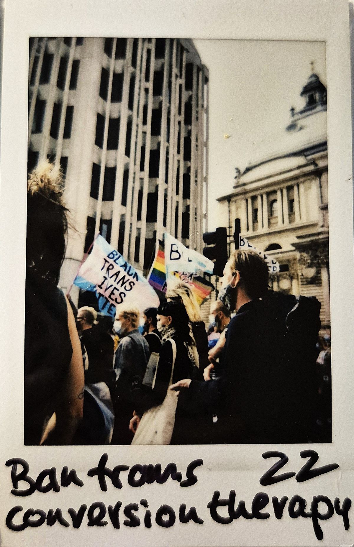 A group of people march, holding signs that advocate for the rights of transgender individuals.