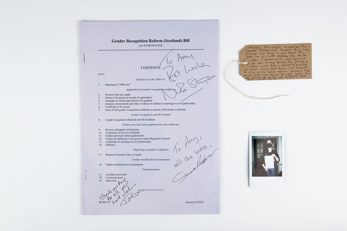 A copy of the Gender Recognition Reform (Scotland) Bill, signed by Nicola Sturgeon, Shona Robinson and Joe. With a polaroid of the donor and a brown handwritten luggage tag.