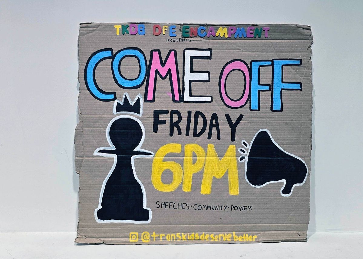 A hand drawn cardboard Trans Kids Deserve Better placard with text "COME OFF FRIDAY 6PM - SPEECHES COMMUNITY POWER" in blue, white, pink, black and yellow text. It also features the silhouette of a pawn and a megaphone.