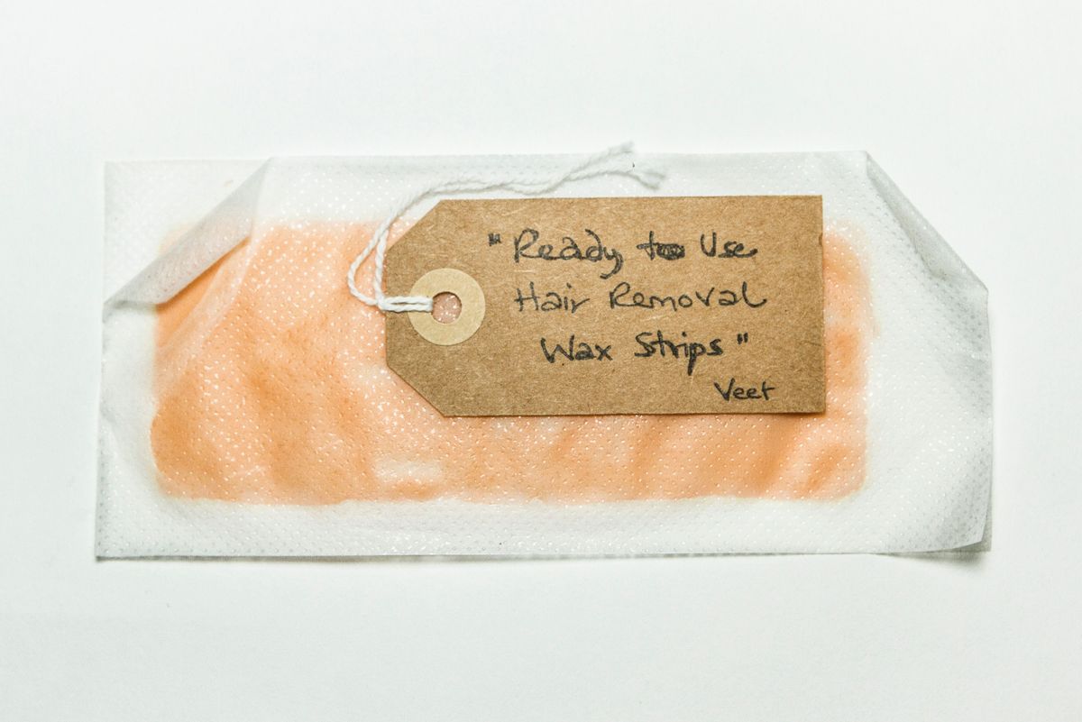 2 sheets of plastic with pink wax inbetween. Edges have curled up on covers, strip has curved up & down at one end.