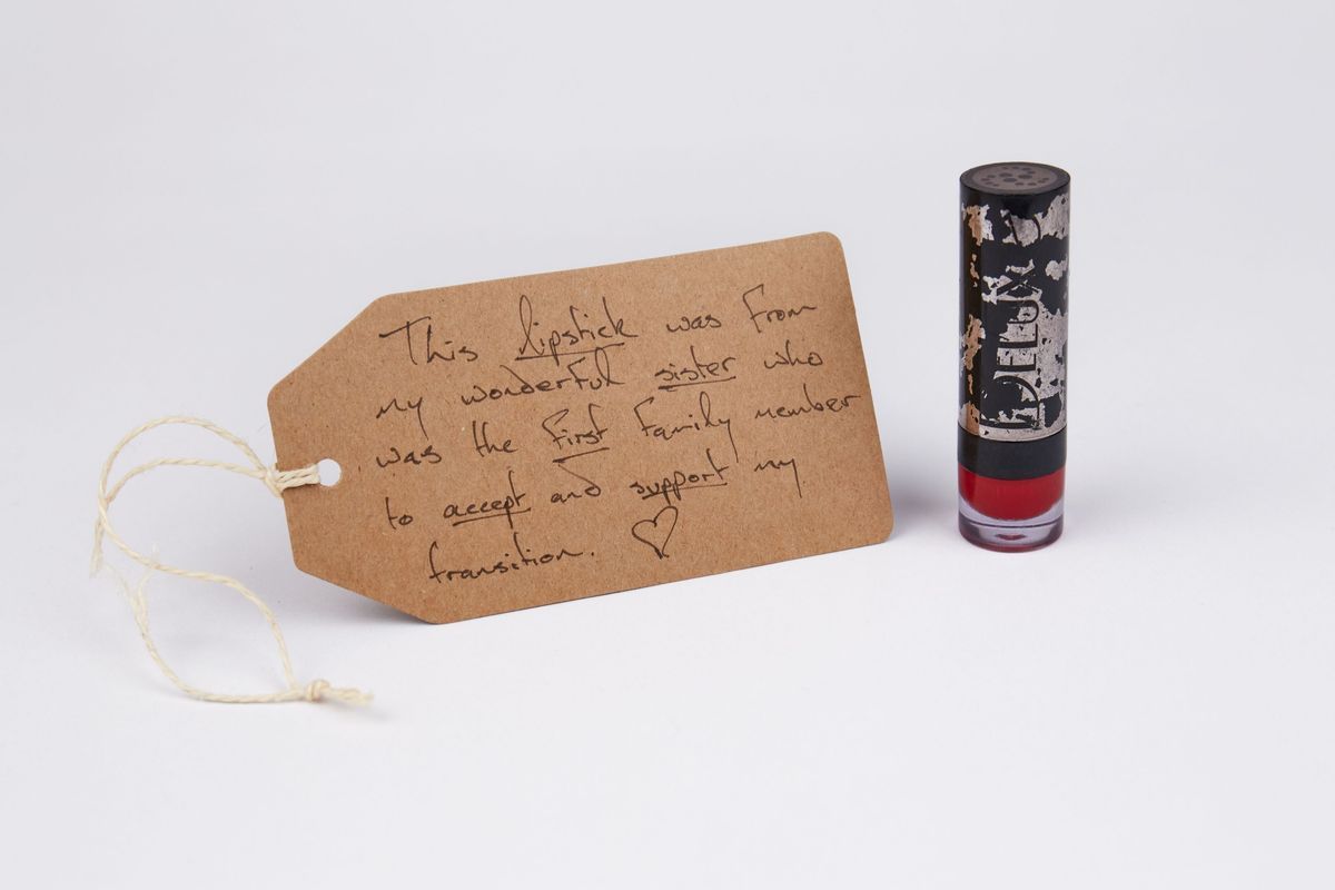 Black lipstick tube. Some of the black paint has been stripped away revealing silver underneath.