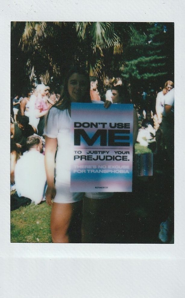 A person is holding a sign which says "DON'T USE ME TO JUSTIFY YOUR PREJUDICE".
