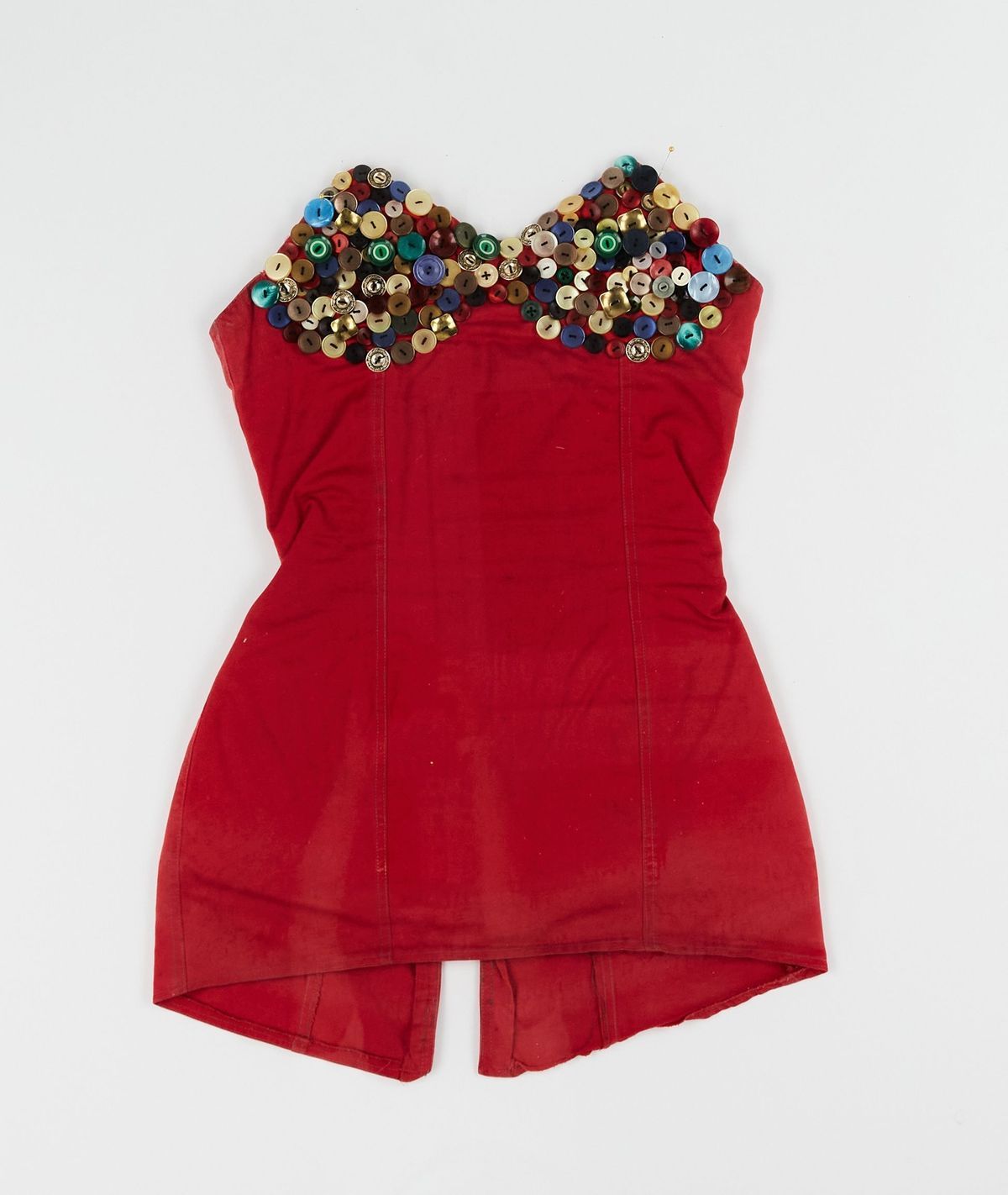 The red dress features a bust adorned with colorful, decorative buttons, giving it a unique and festive look.