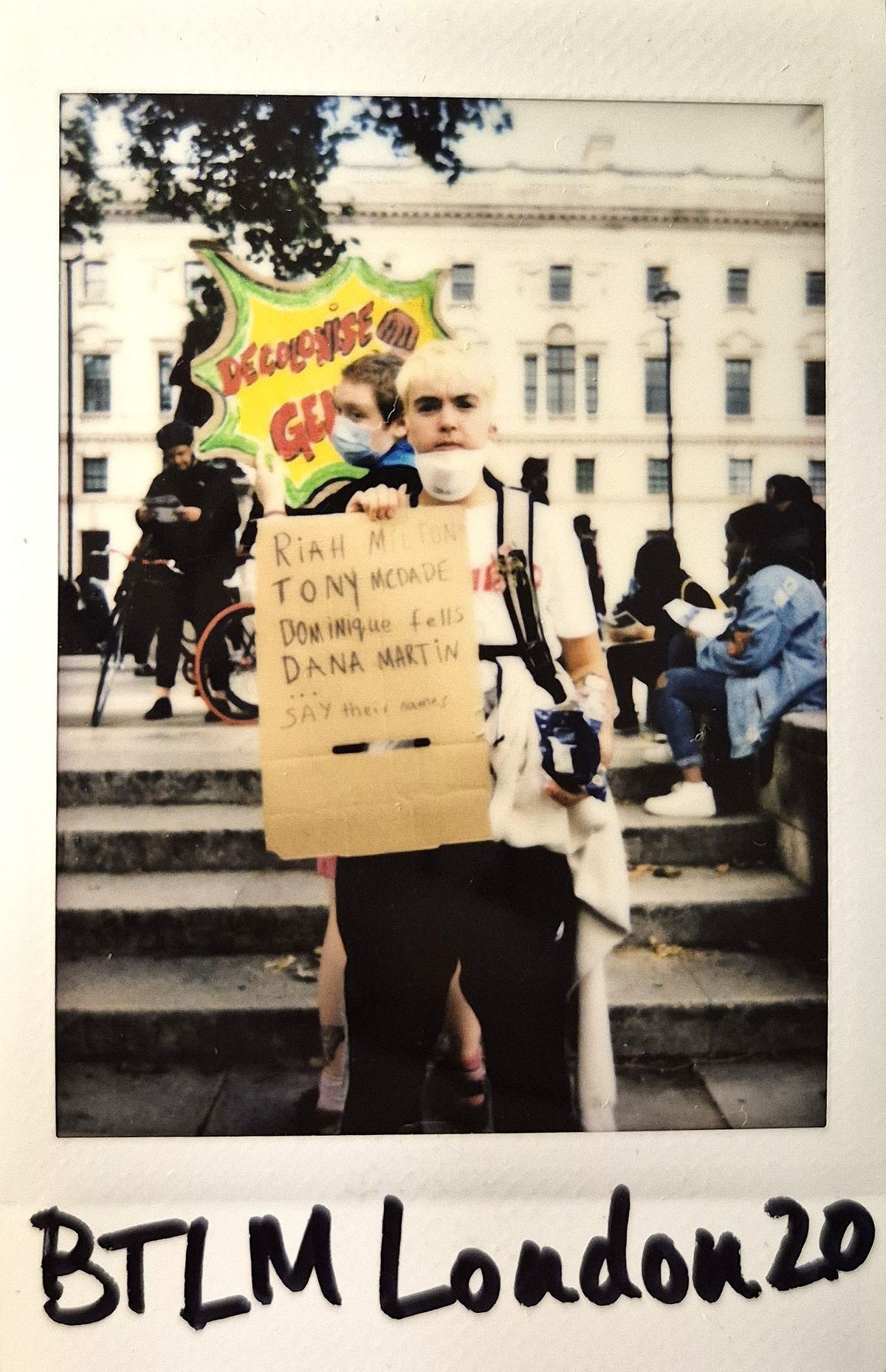 A person holds a protest sign listing the names of Black trans people.