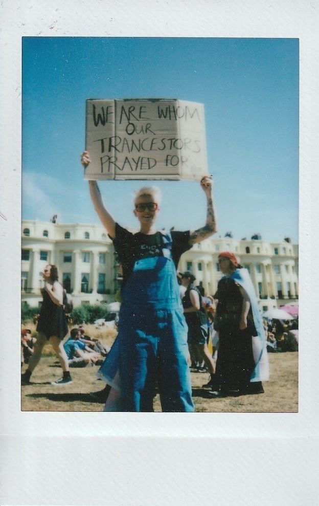 A person proudly holds a sign reading, "We are whom our ancestors prayed for".