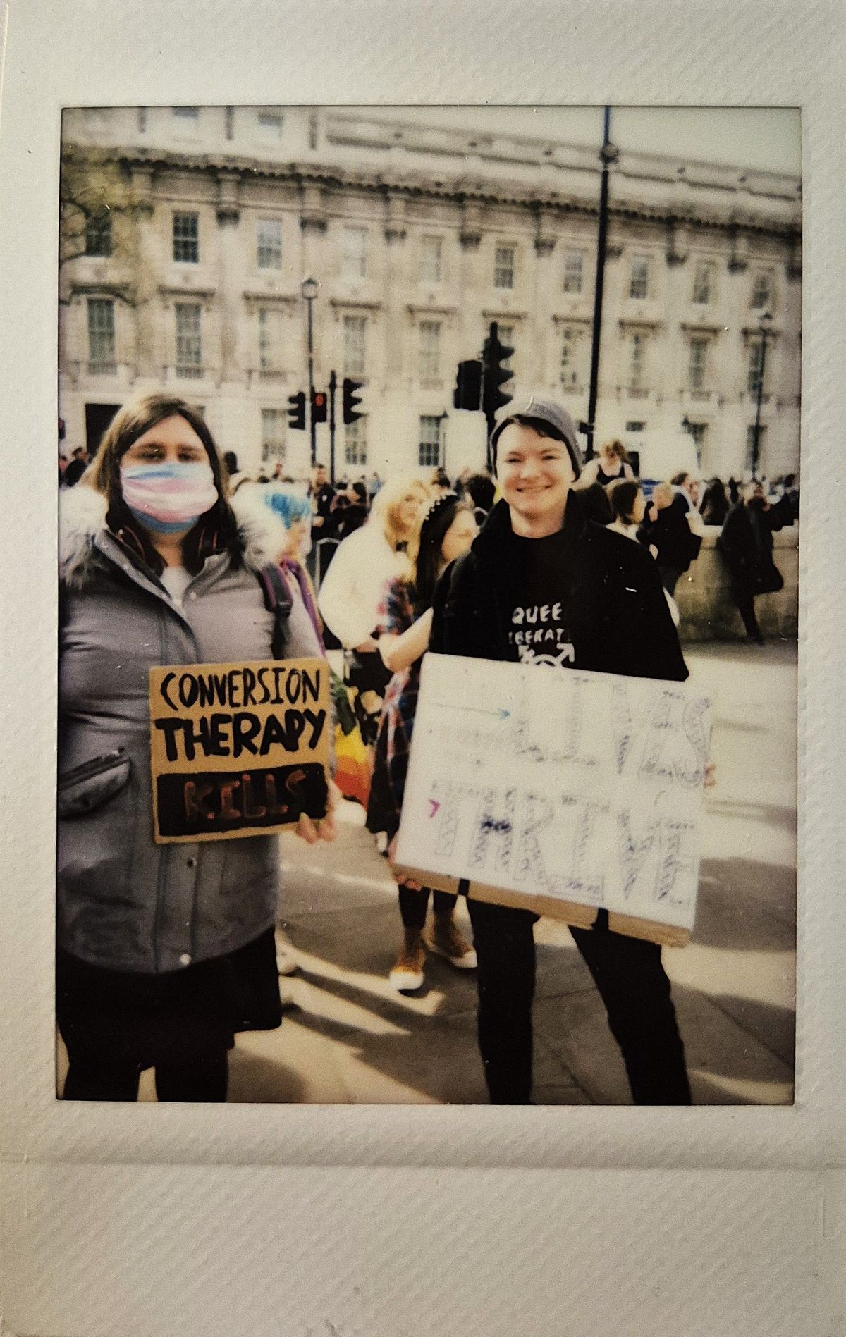 Two people hold protest signs against conversion therapy. One says "CONVERSION THERAPY KILLS".