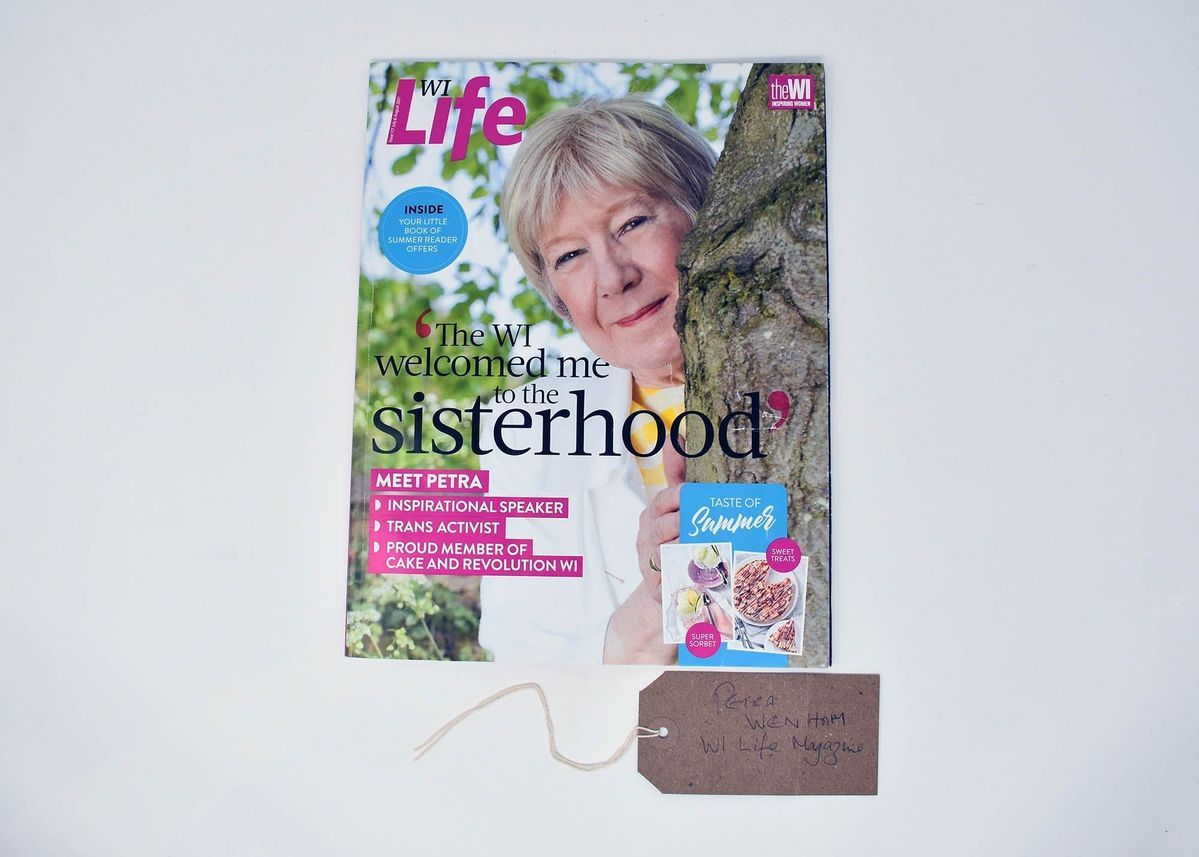 A magazine called WI Life which says 'The Wi welcomed me to the sisterhood' with an older woman poking her head out from the side of a tree.