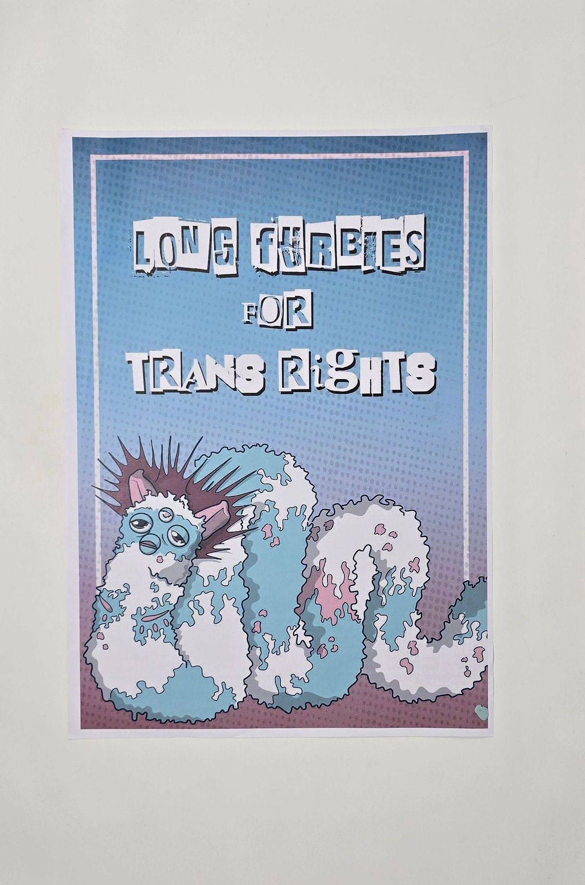 A poster which says 'Long Furbies for Trans Rights' and has an illustration in blue, pink and white of a long furby.