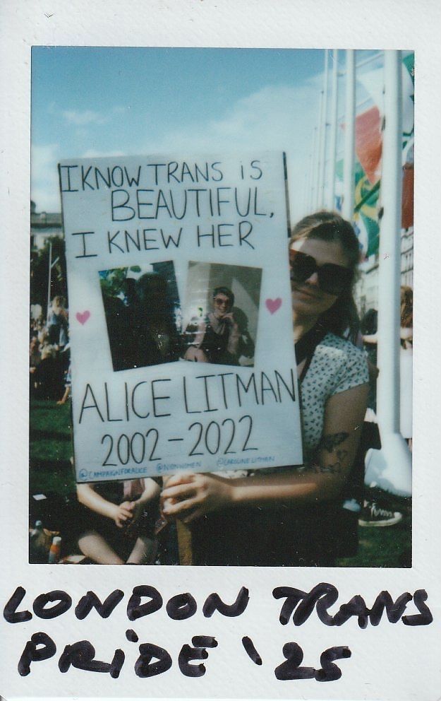 A person holds a sign which says "I Know Trans Is Beautiful, I Knew Her Alice Litman 2002 - 2022".