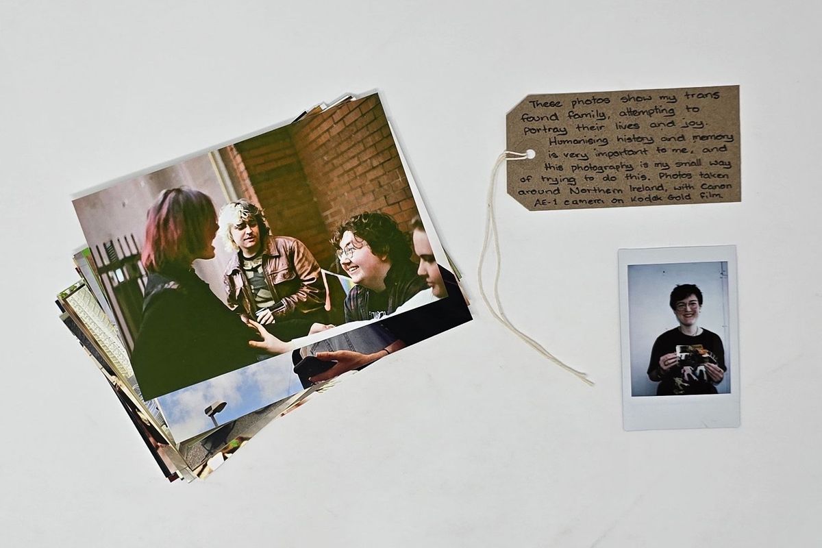 A set of photographs which are lay on top of each other so just on is visible which shows a group of people talking and laughing. The photographs are next to a luggage tag with writing on it and under that a polaroid of a person (the donor) holding the photographs.