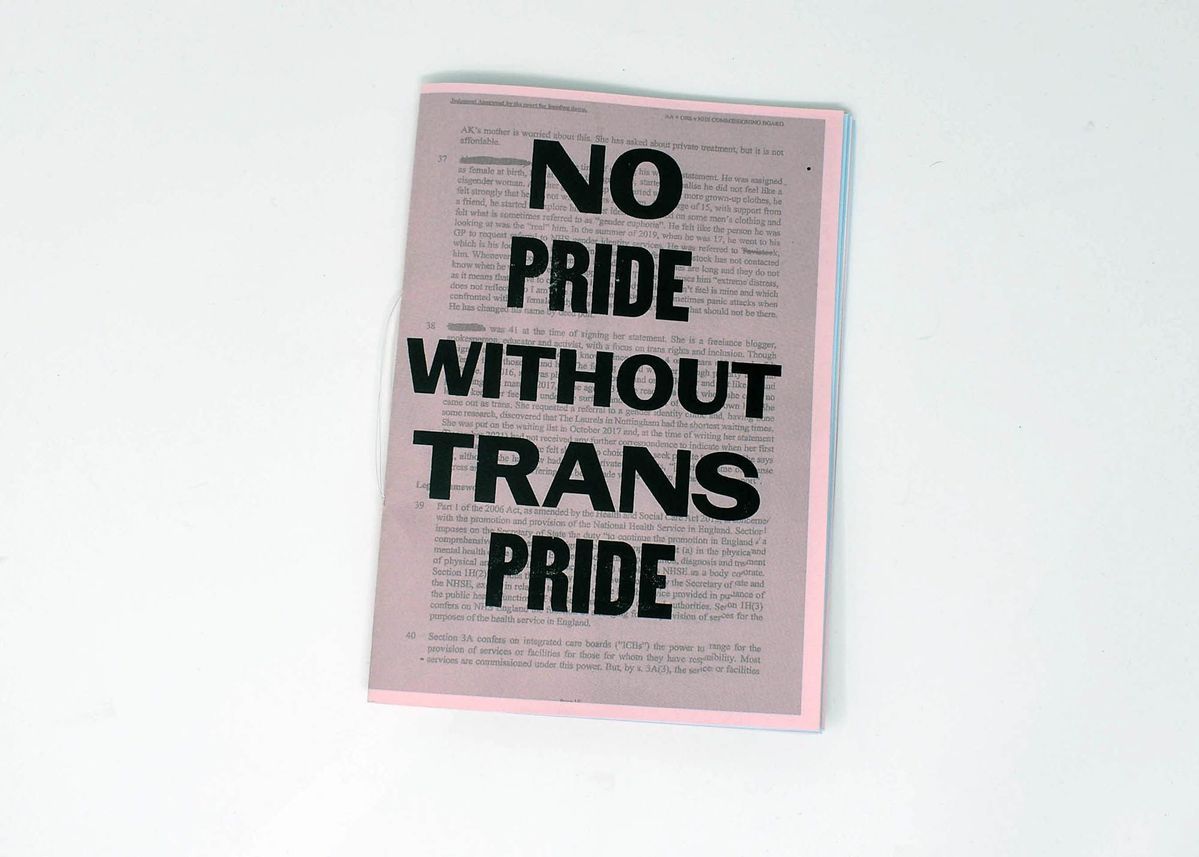 A zine on a white surface states, "No Pride Without Trans Pride," in bold letters.