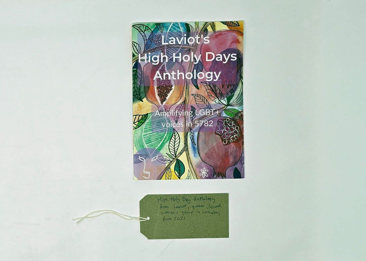 Booklet, with a colourful drawn cover of fruits and leaves,  entitled "Laviot's High Holy Days Anthology" " Amplifying LGBT+ voices in 5782". With a brown, handwritten luggage tag.