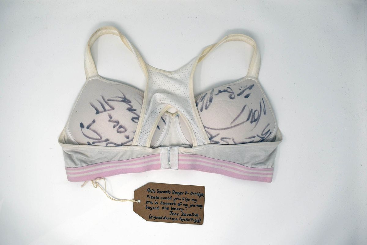 White sports bra with pink bank and various signatures written on the cups in ink.