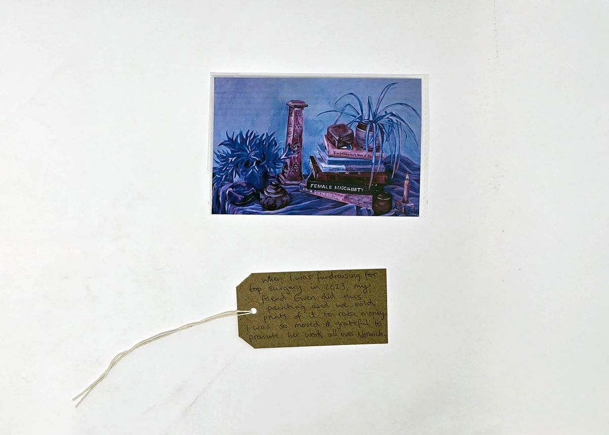 A painting of still life in blues and pinks and a brown luggage tag.