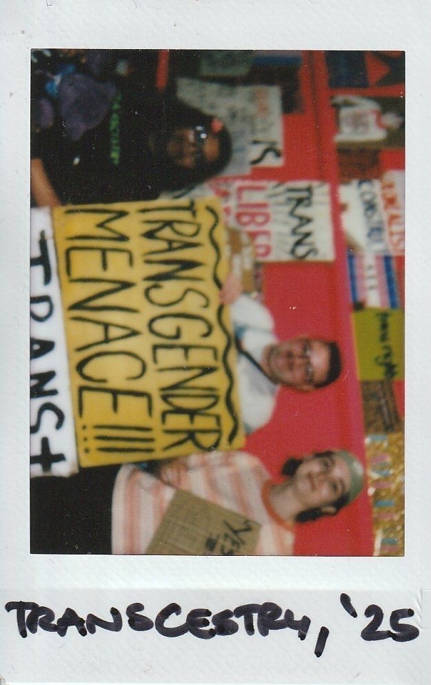 Three people are holding signs with messages in a vibrant room.