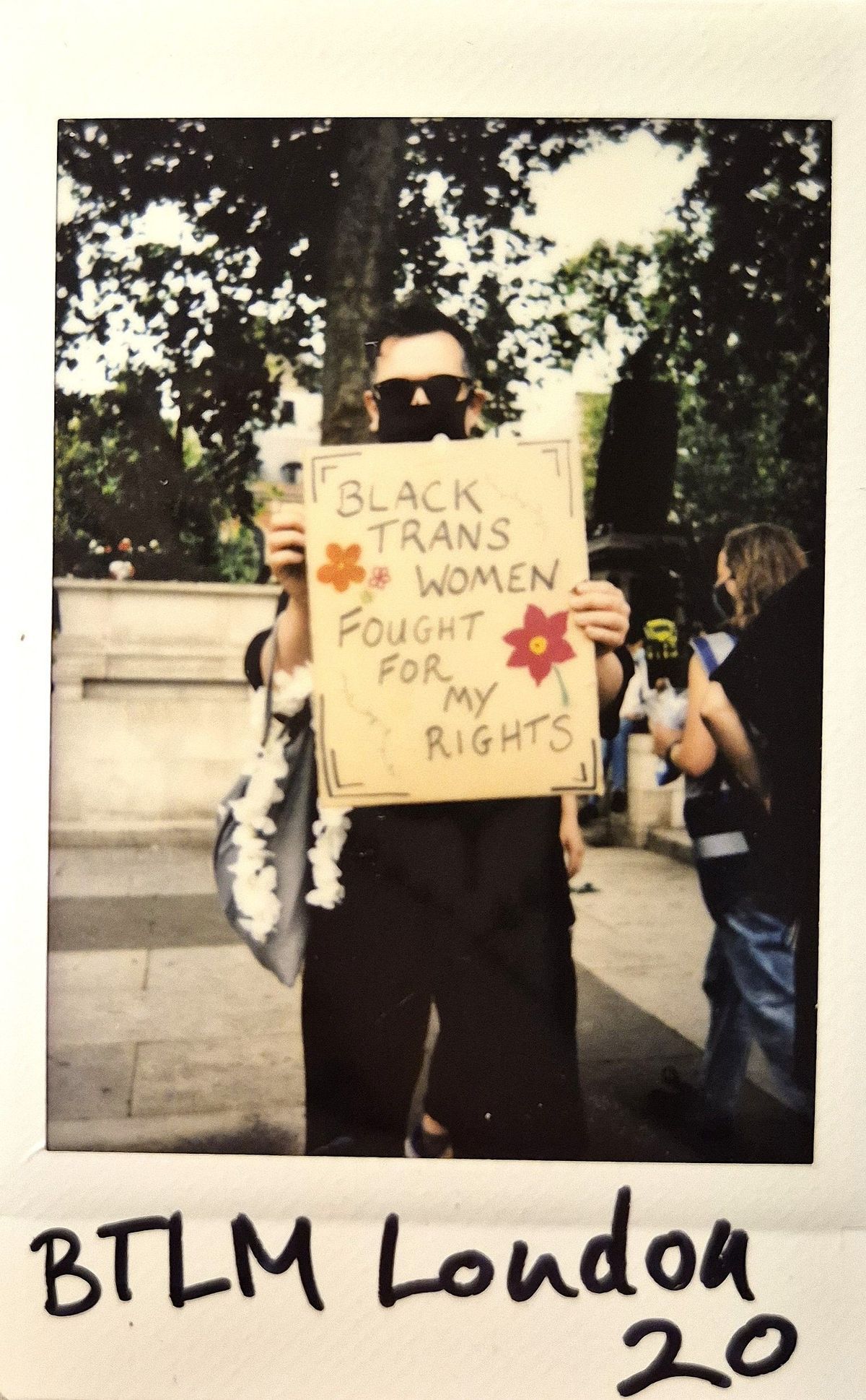 A person holds a sign reading "Black trans women fought for my rights" at a protest.
