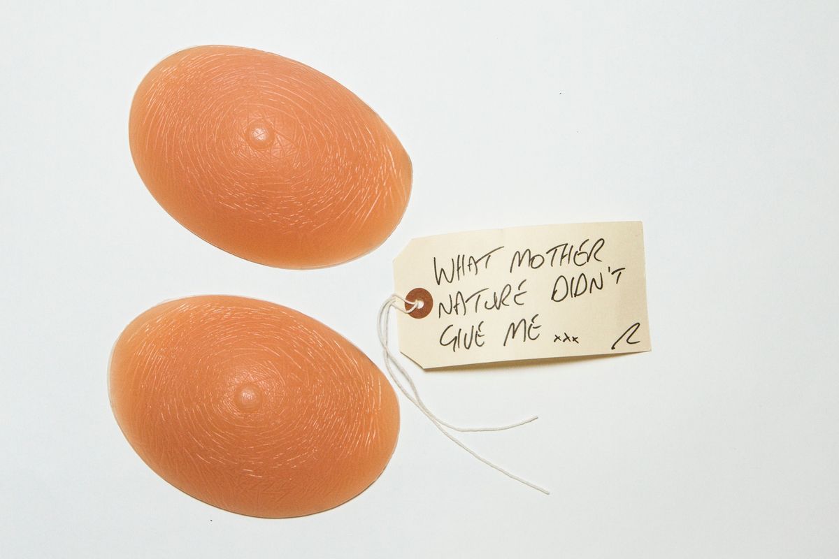 Pair of prosthetic silicone breasts & tag; oval shaped, flesh pink, solid, moulded with flat back (base) with concave indent, moulded with lines of skin detail. Round small nipple. Brand name on back of breasts "Softleaves" UK [Lot 67] Classic x 100"