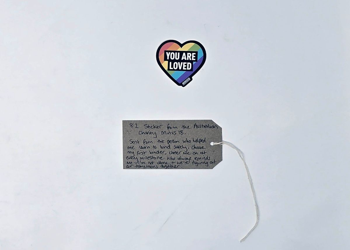 The image shows a heart-shaped sticker and a handwritten note with supportive messages attached.