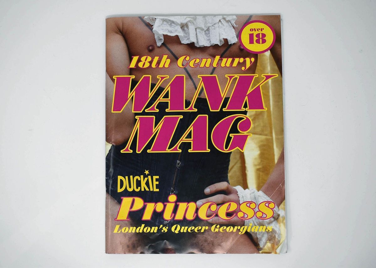 Pamphlet with a photo of a person wearing a black corset. Over the image there is yellow and pink block text reading "18th Century WANK MAG".