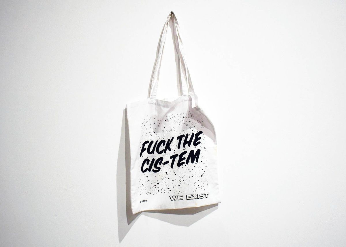 A white tote bag which says 'Fuck The Cis-Tem' on it.