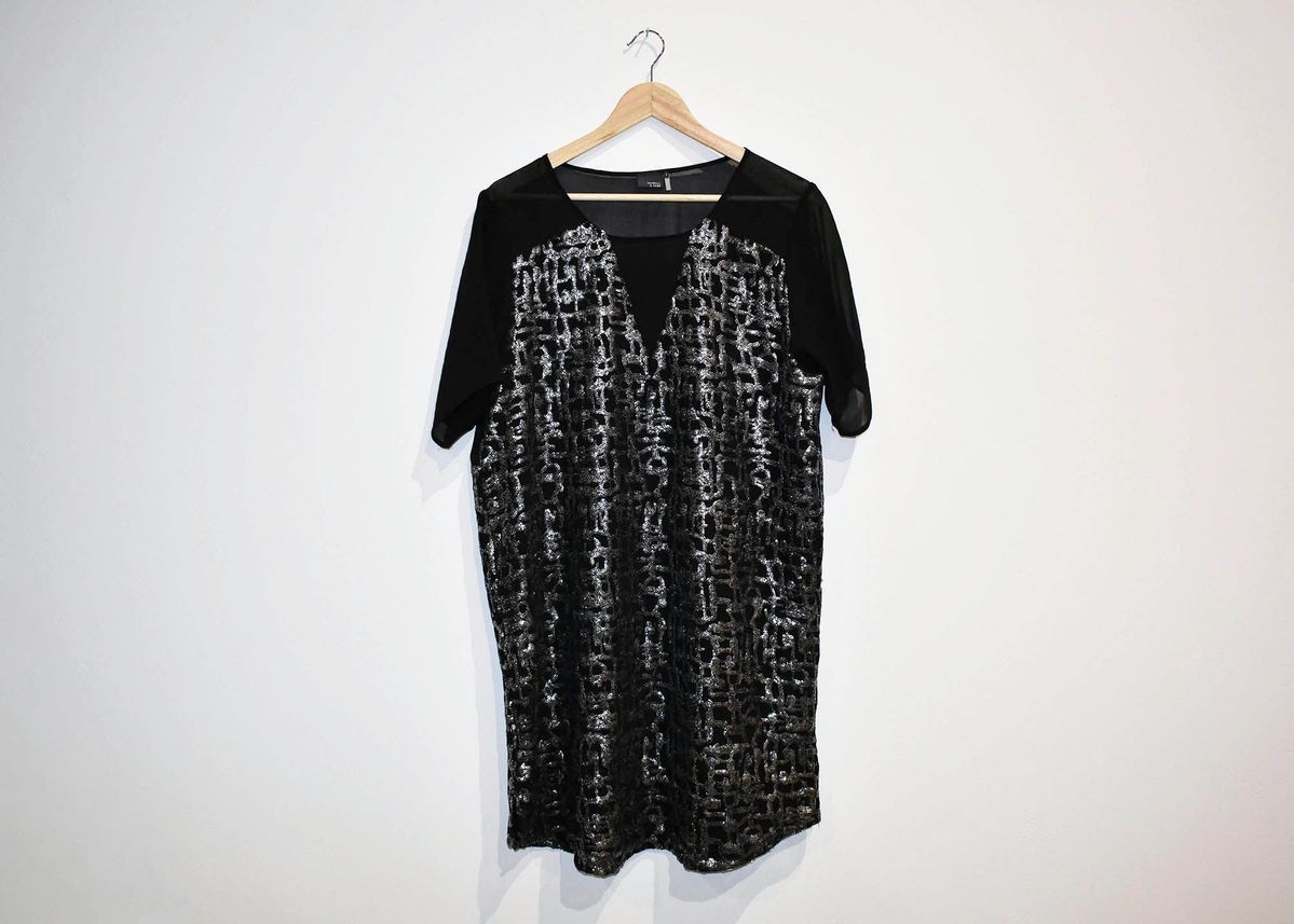 Black and sliver dress on a wooden hanger.