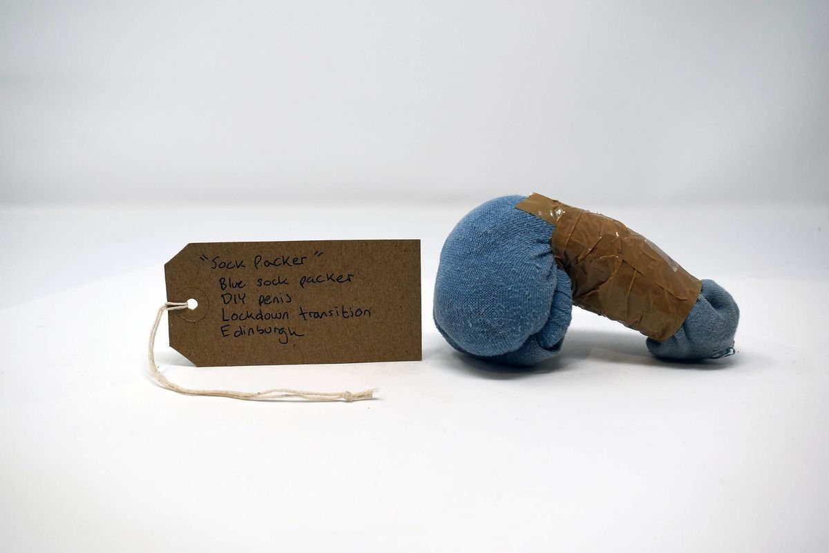 A homemade packer constructed from a blue sock and brown tape. With a brown, handwritten luggage tag.