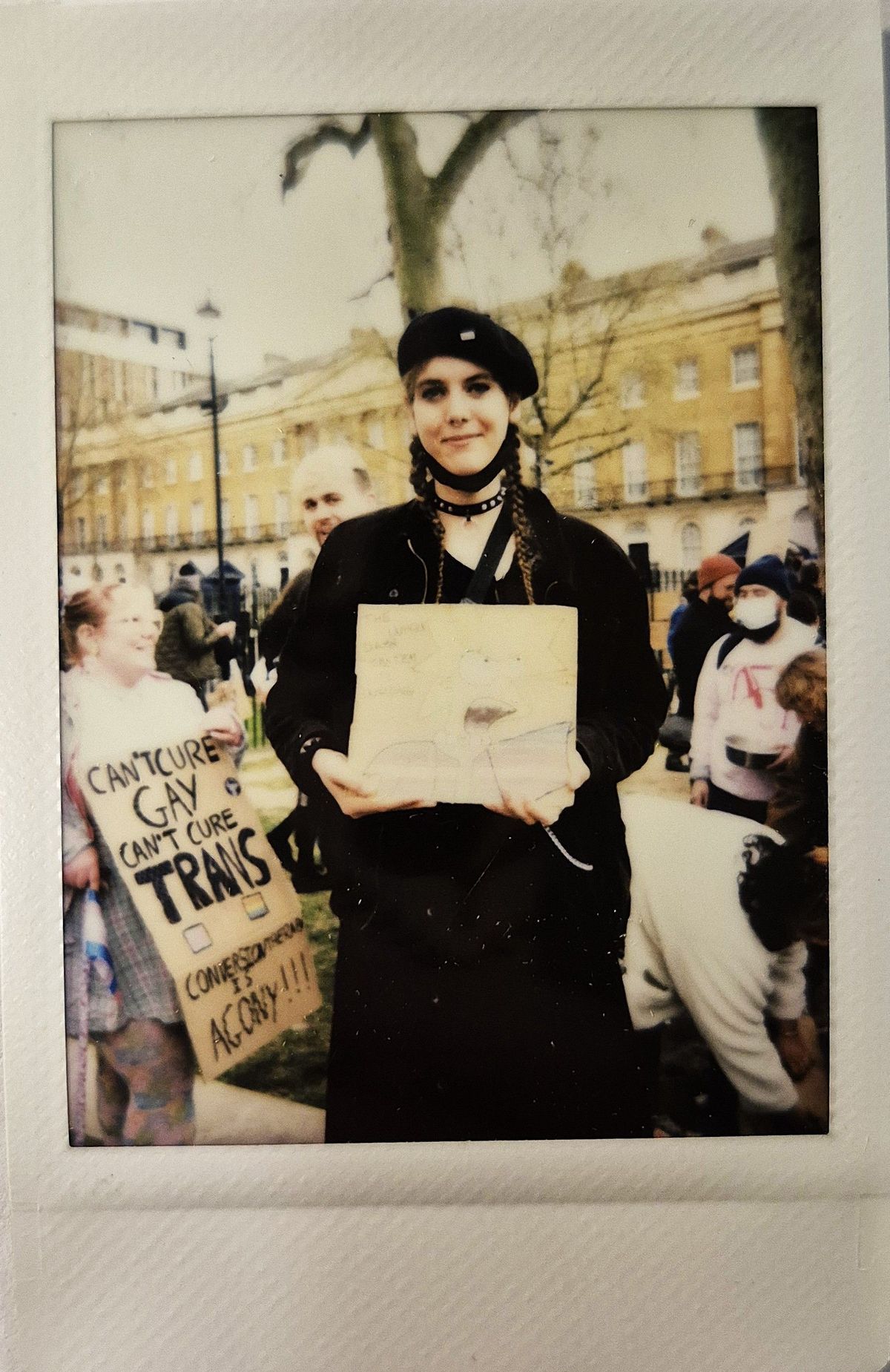 A person holds a sign which is too blurry to make out.