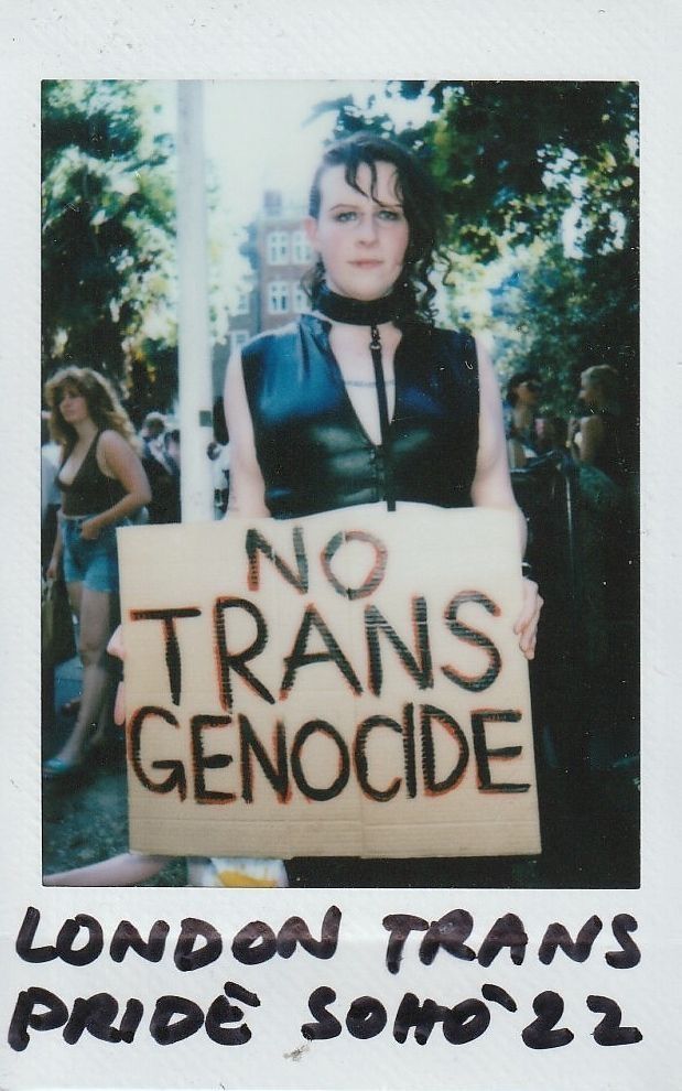 A person holds a "No Trans Genocide" sign at London Trans Pride, Soho, 2022.