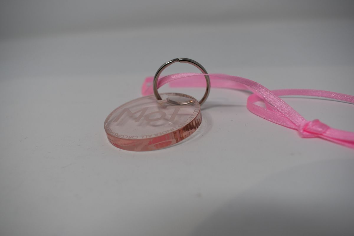 Perspex clear pink circular disc keyring 40mm diameter hanging on metal split ring 25mm diam. With narrow pink ribbon attached approx.. 400mm length. Excellent condition. Disc inscription reads " MoT…to remain collected under all circumstances….Museum of Transology"