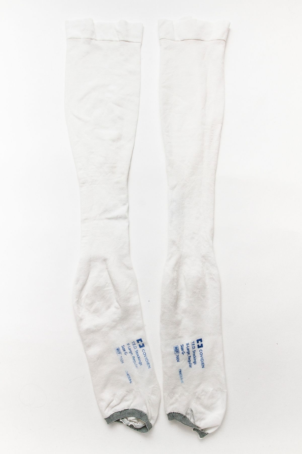 Worn white stockings with grey elastic bottom.