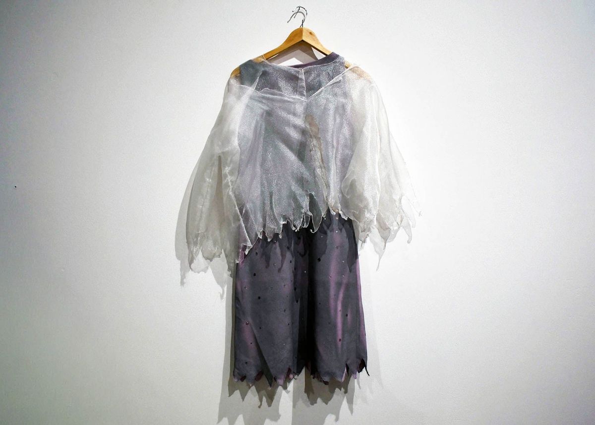 Fancy dress top; white iridescent fine synthetic net fabric, short sleeved, handmade, made in two layers with pointed zig zag edge to hems which are overstitched. Small metal press stud fasteners at neck and back edge, V shaped front neck with press stud. T