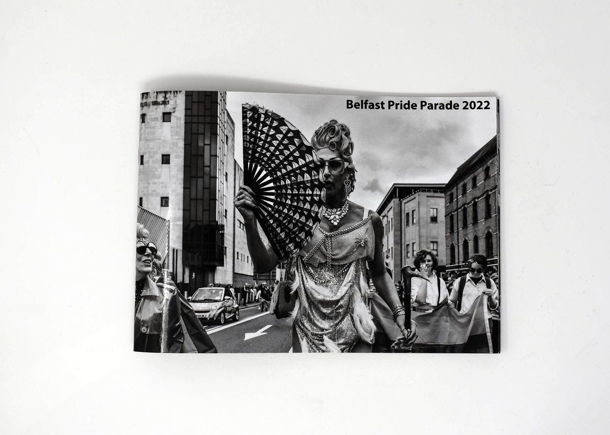 Black and white booklet with person on front holding a fan. "Belfast Pride Parade 2022"