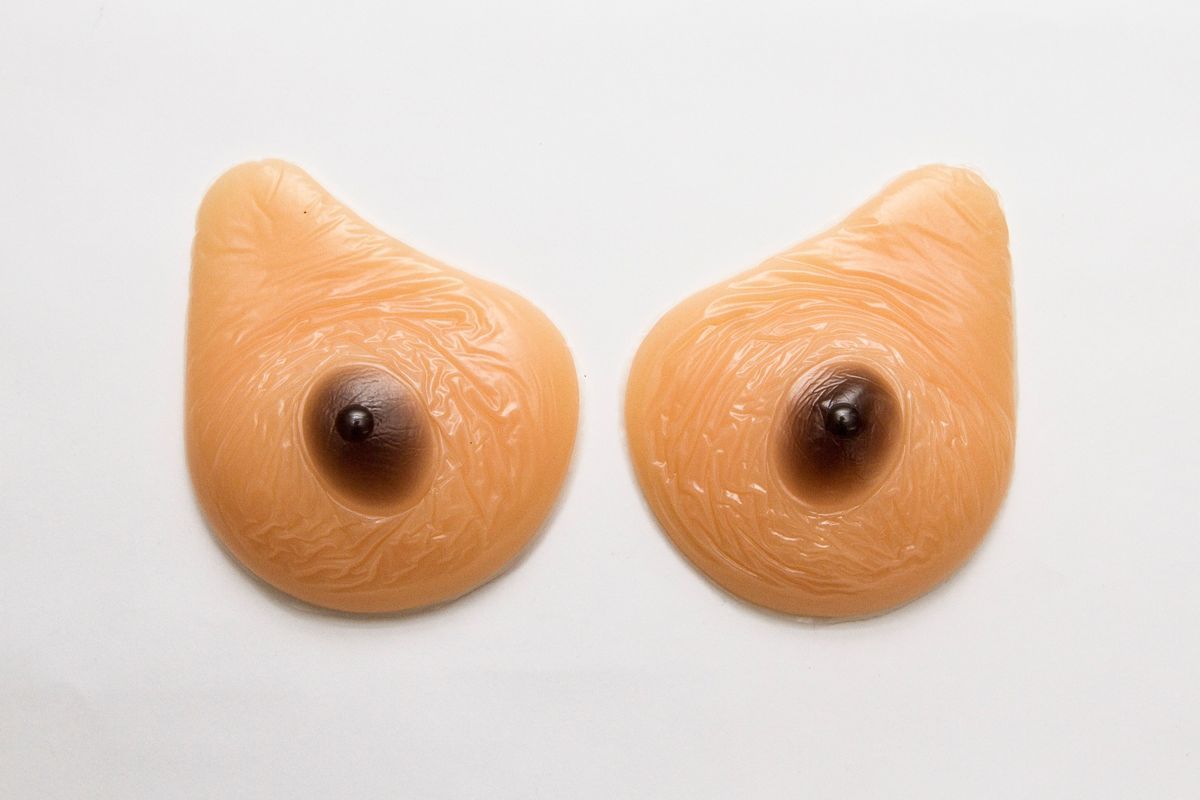 Pair of silicone gel filled prosthetic breasts & tag; Pear shaped, Silicone gel held in outer layer. Dark brown nipples & aureoles. Brand name on back "Softleaves" Reel Look UK [Lot 99] 27111".