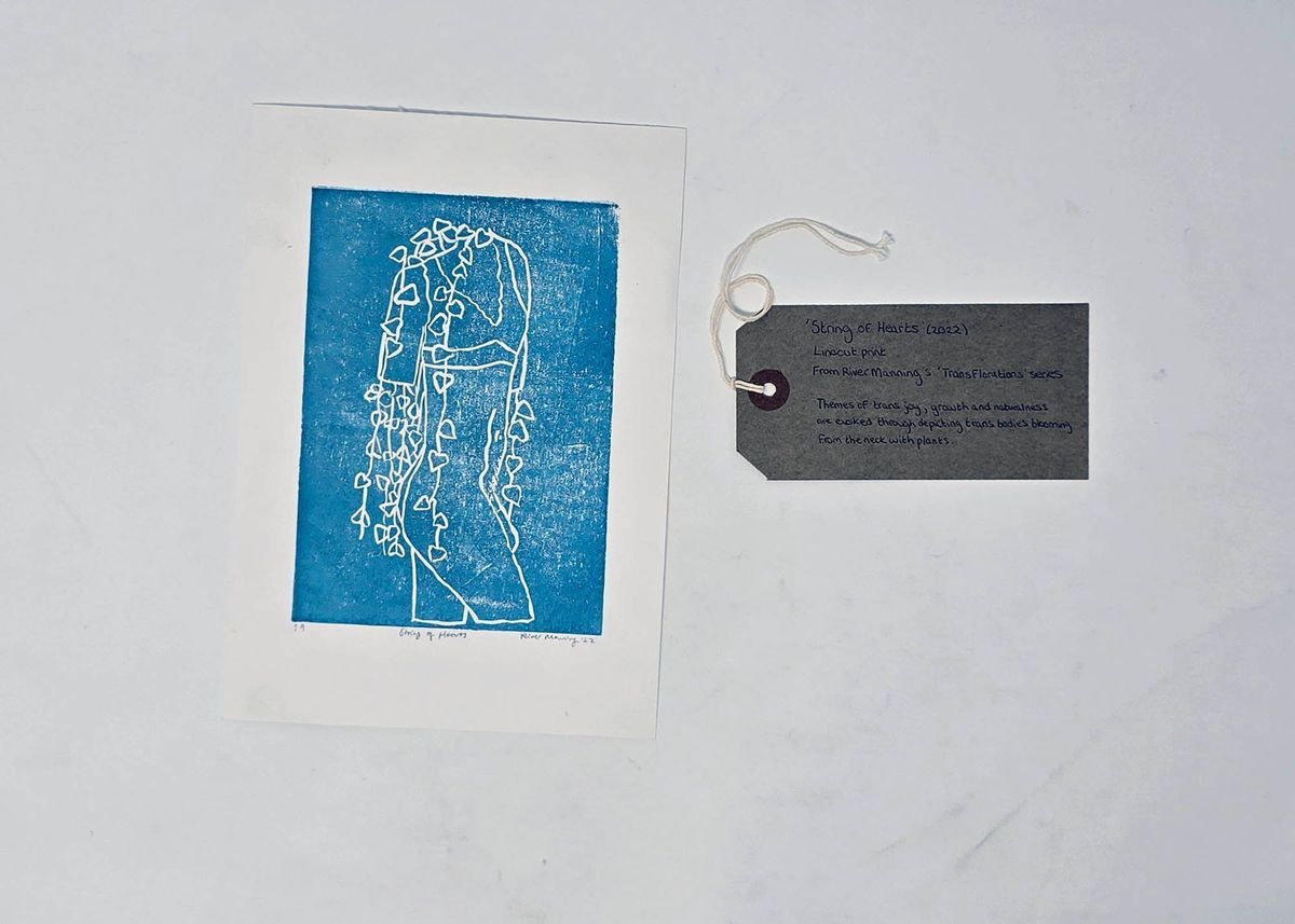This image shows a blue linocut print depicting a headless figure with heart-shaped vines draping down from their neck. With a brow, handwritten luggage tag.