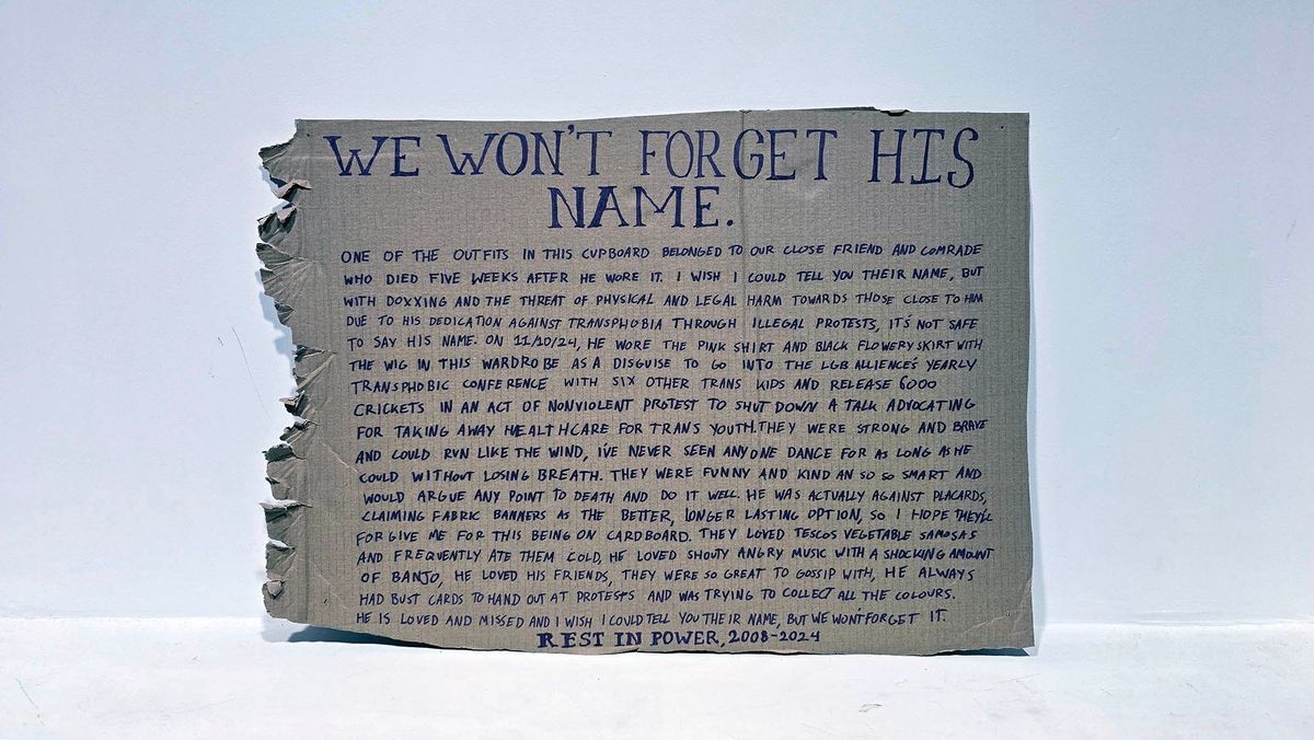 A cardboard placard with handwritten memorial about a person's activism and remembrance.
