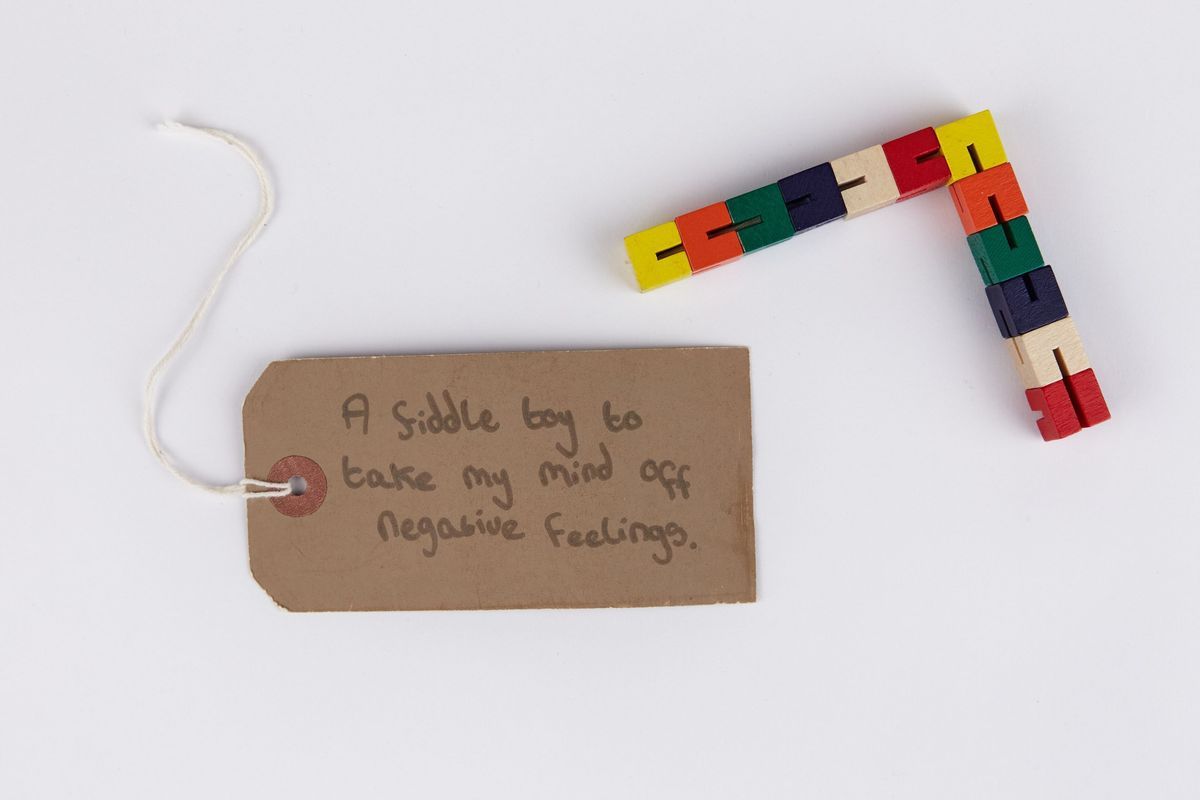 12 colourful cubes linked together by a piece of white elastic thread.