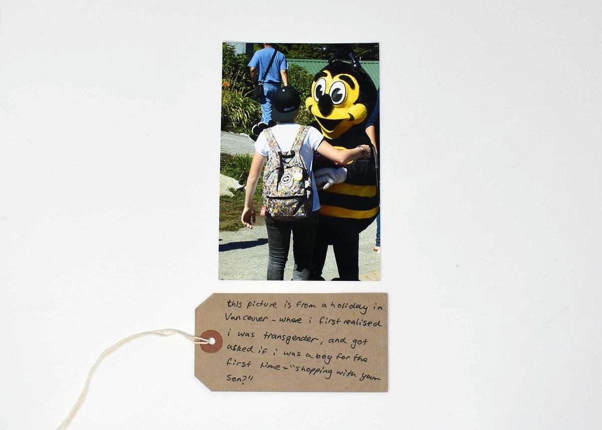 Photograph A6 size; picture of person in baseball hat & man in bee costume.
