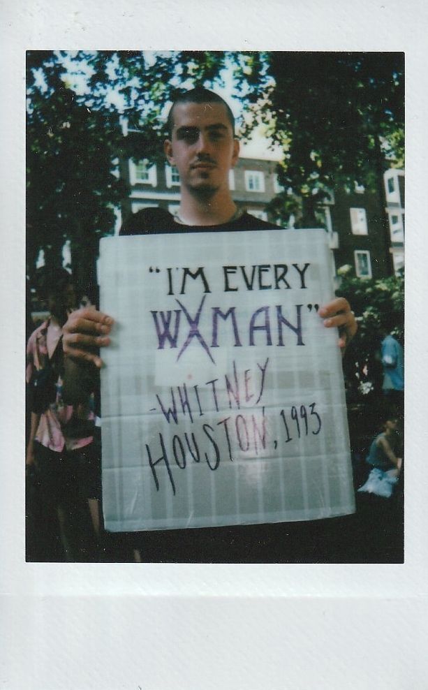 A person holds a sign quoting Whitney Houston's 1993 hit but a slightly different take "I'm Every WXMAN".