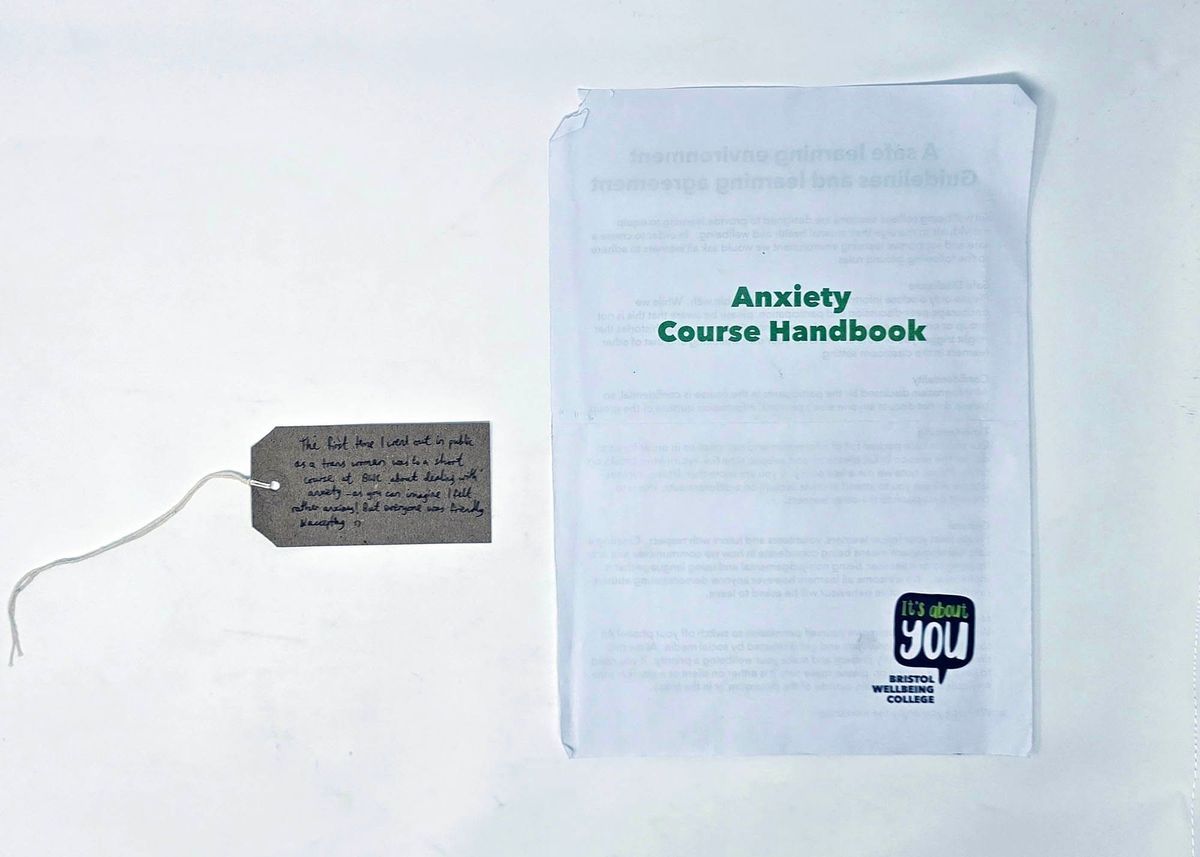 An Anxiety Course Handbook from Bristol Wellbeing College, with a brown handwritten luggage tag.