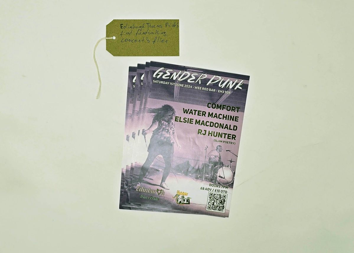 Four copies of a flyer advertising Gender Punk fundraising concert. It lists the performers and the background image is of a person playing drums and another person holding a microphone and headbanging. With a brown, handwritten luggage tag.
