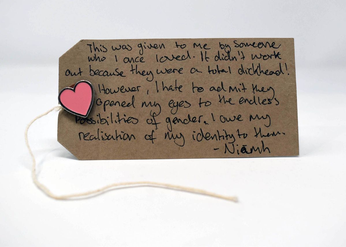 Metal enamelled pink heart shaped pin badge.