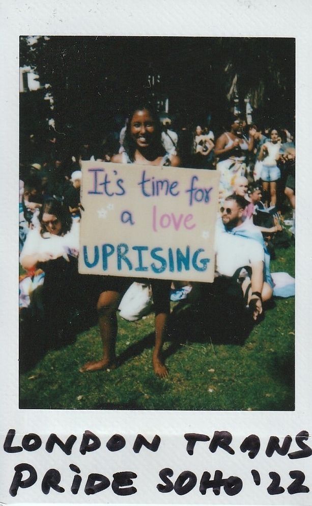A person holds a sign reading "It's time for a love uprising" at London Trans Pride.