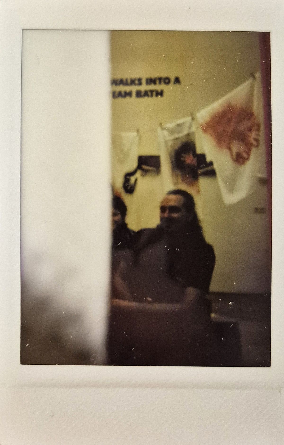 The image shows a partially obscured dimly lit scene with people sitting.