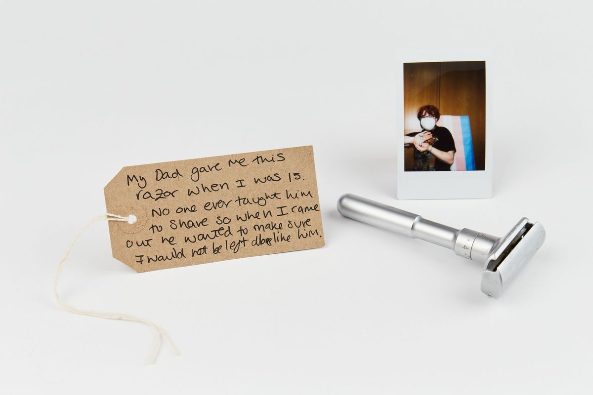 A razor, handwritten note, and photograph are carefully arranged on a white surface.