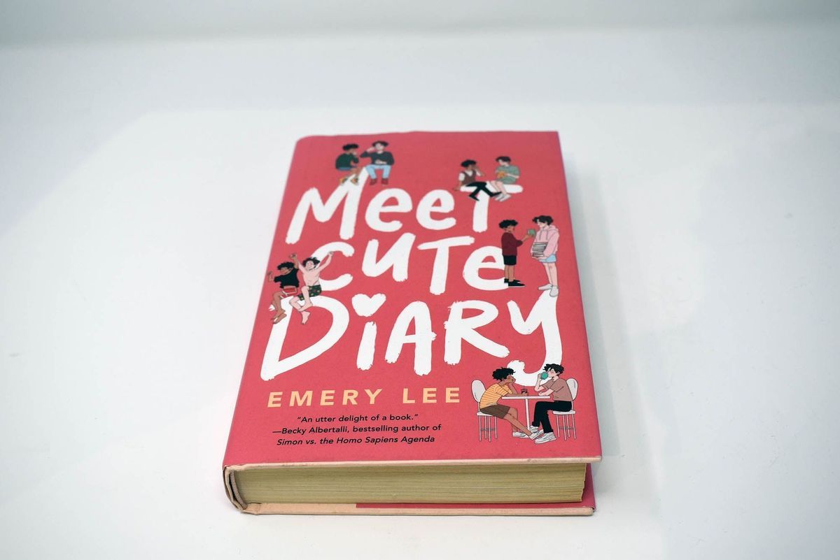 The book "Meet Cute Diary" by Emery Lee features an illustrated pink cover.