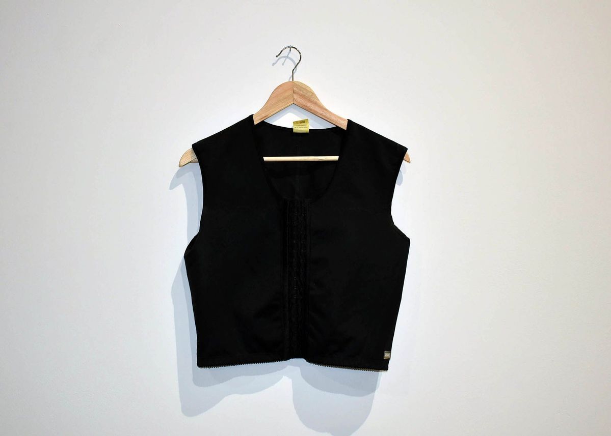 Black half-length binder with hooks in the front. A small white tag is visible on the back of the neck.