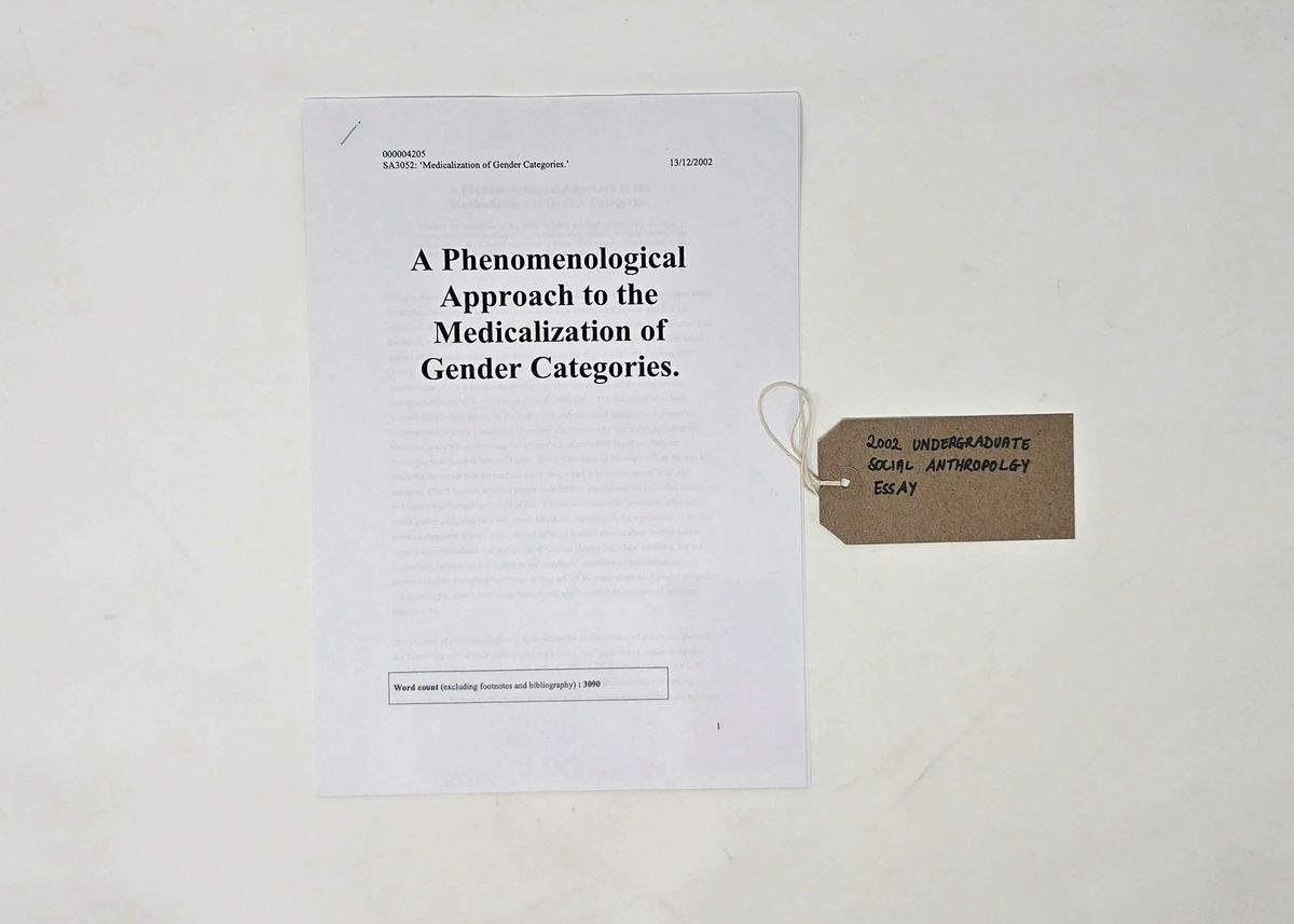A printed copy of an undergraduate Social Anthropology essay titled "A Phenomenological Approach to the Medicalization of Gender Categories. With a brown handwritten luggage tag.
