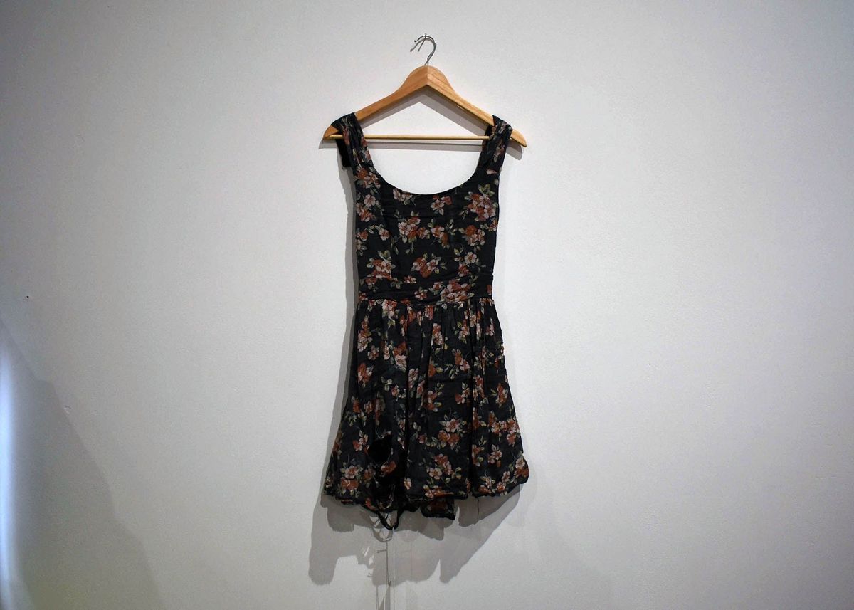 Black sleeveless dress with pink and white flower pattern.