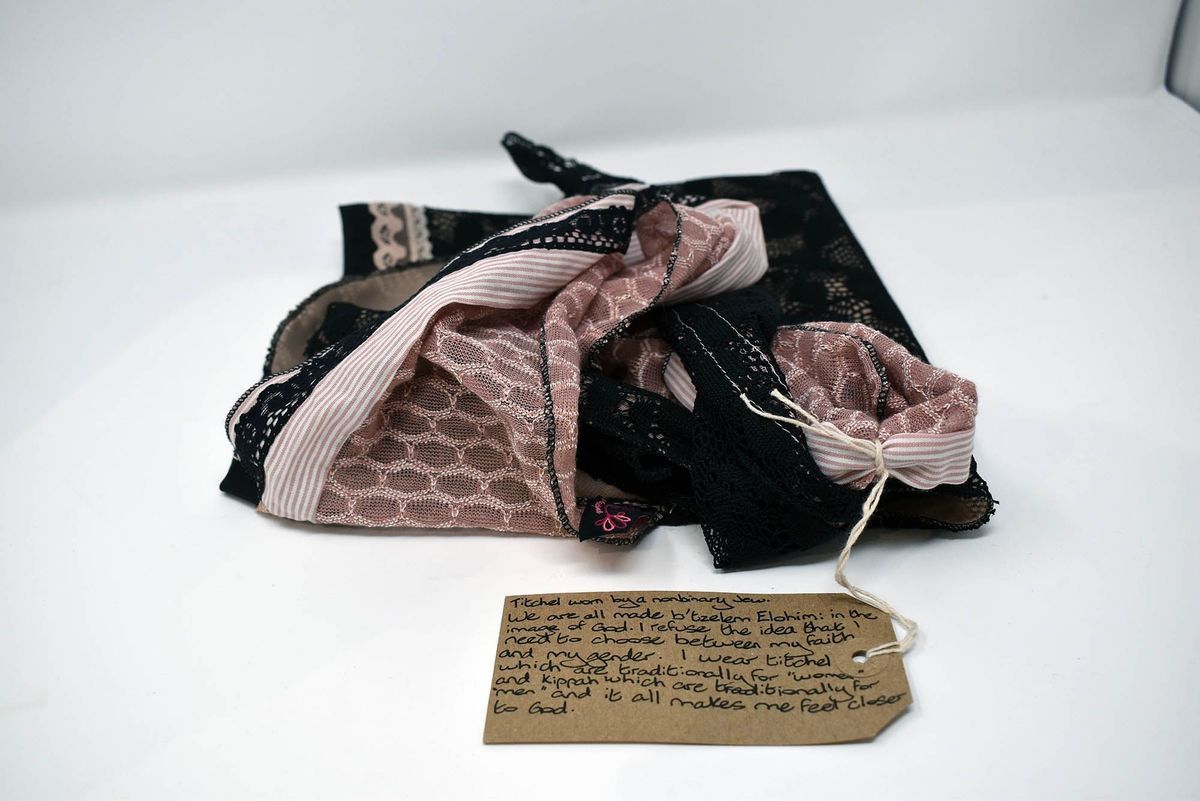 A tichel is displayed with a handwritten tag containing a reflective and personal message.